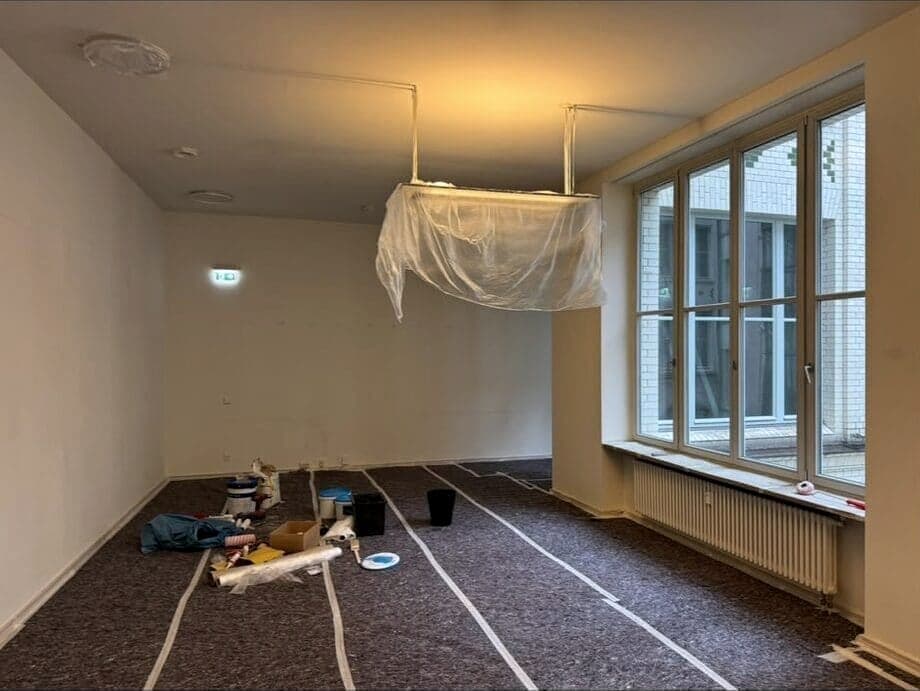 Wohnraum während der Malerarbeiten, Boden abgedeckt und Leuchte eingepackt