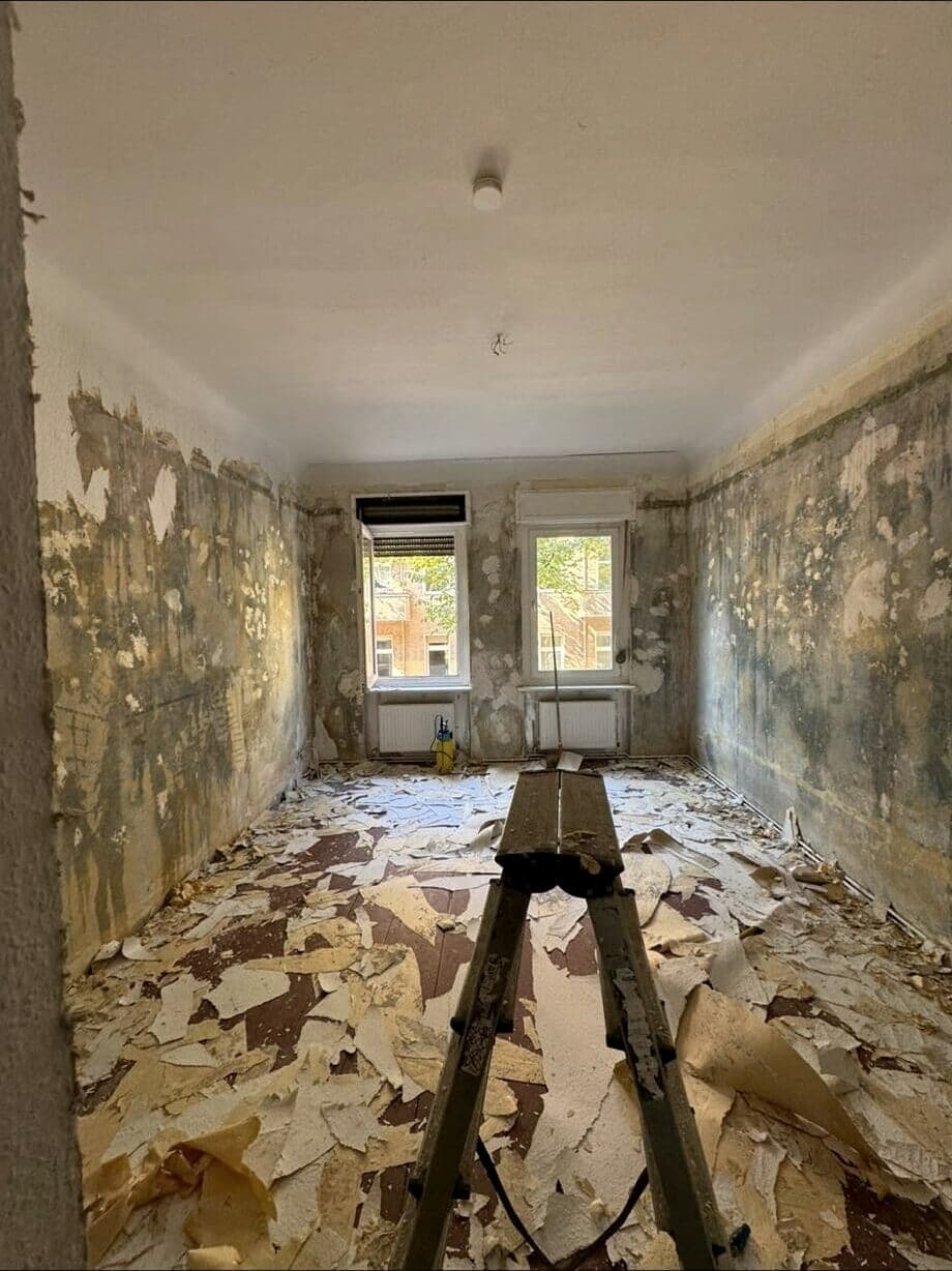 Wohnraum nach der Entkernung mit abgelösten Tapeten