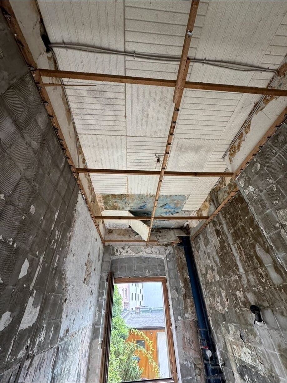 Geöffnete, feuchtegeschädigte Decke im Bad vor der Sanierung