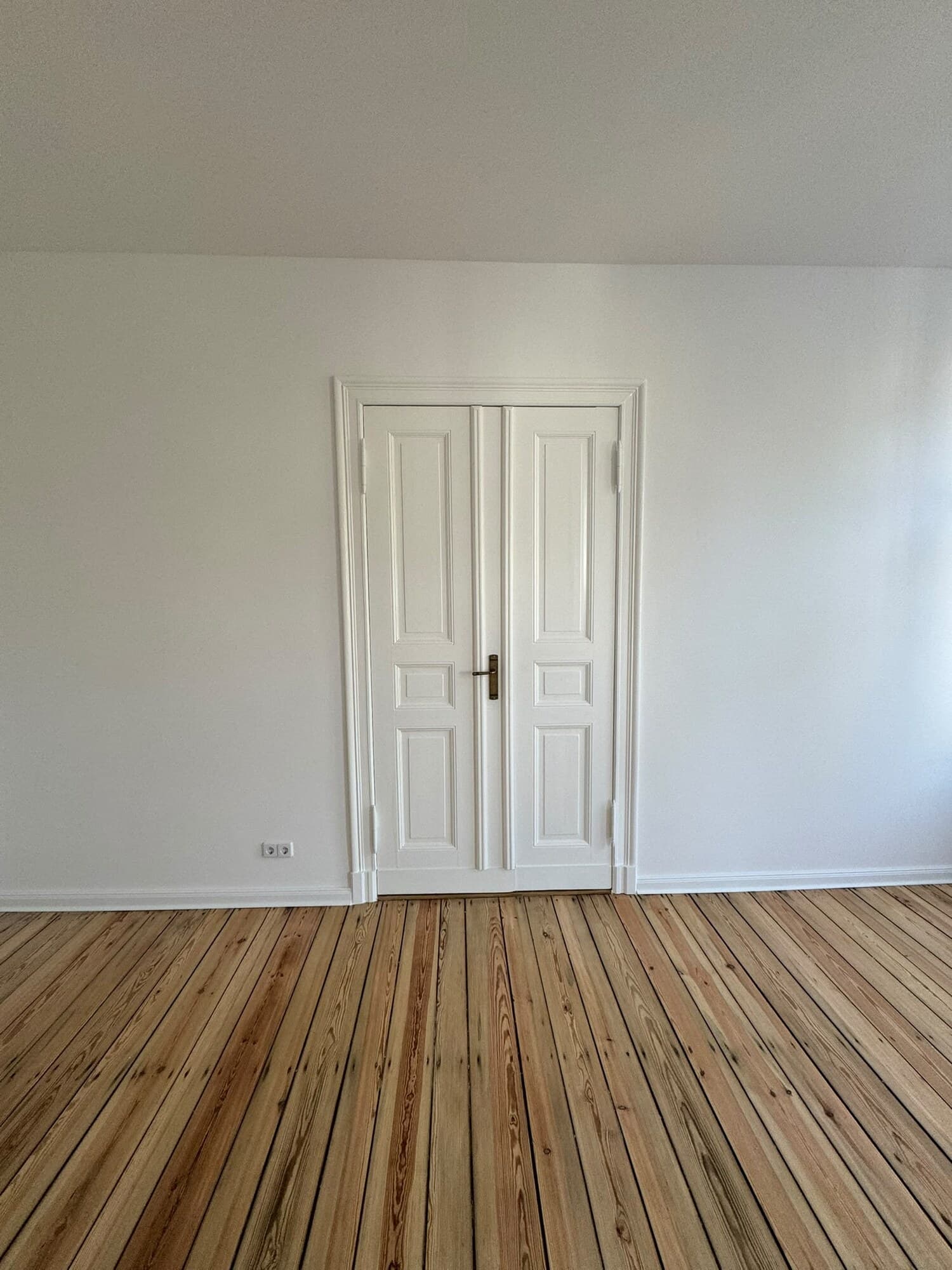 Zimmer mit aufgearbeiteter Flügeltür und Kieferdielen