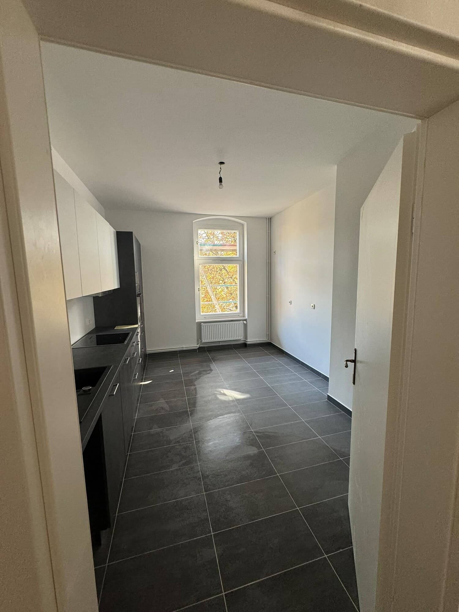 Wohnraum mit Balkontür und Kieferdielen