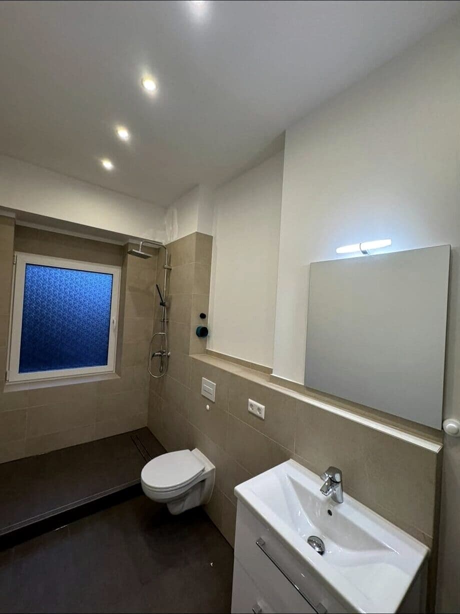 Neues Duschbad mit Dusche an der Fensterwand und neuen Sanitärobjekten