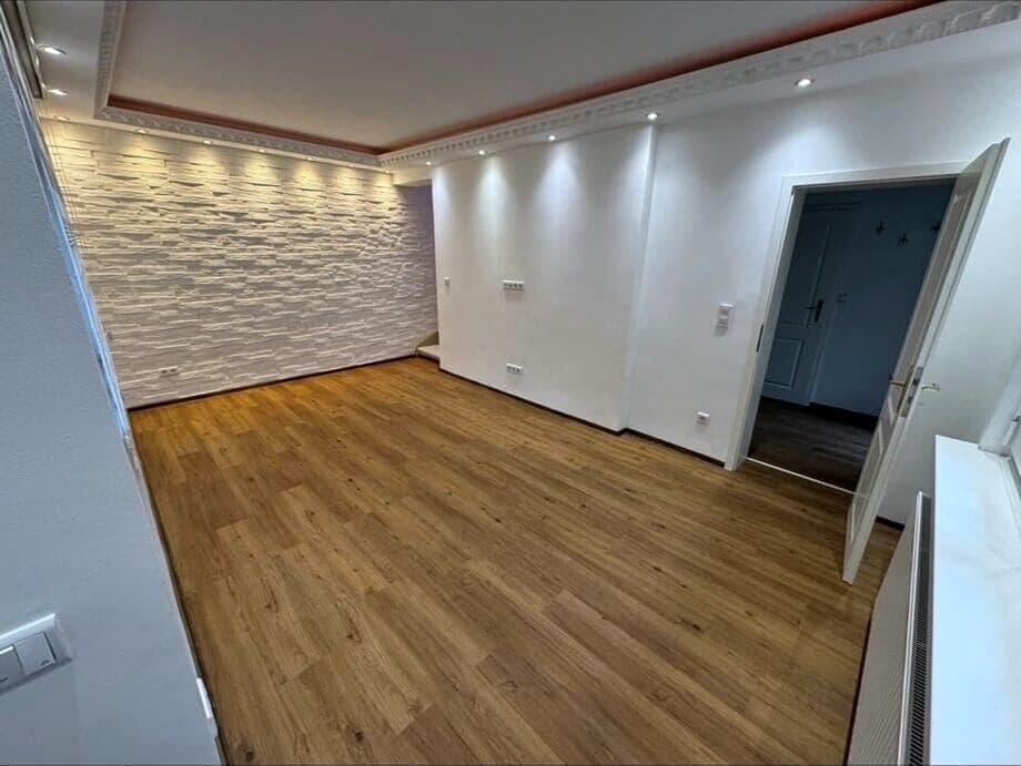 Ausgebauter Raum mit Natursteinwand und indirekter Beleuchtung