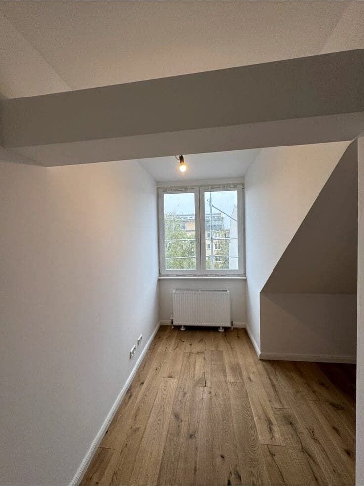 Helles Dachzimmer mit neuem Holzboden nach dem Ausbau